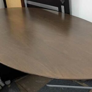 Table design Florence Knoll modèle 2048 édition KNOLL International, plateau ovale en noyer foncé, piètement en étoile à 4 branches. 75 x 244 x 137 cm (démontée). Localisation : ss sol -1