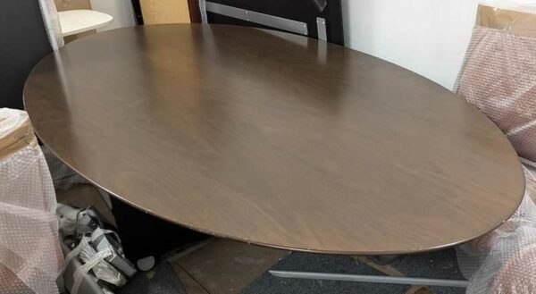 Table design Florence Knoll modèle 2048 édition KNOLL International, plateau ovale en noyer foncé, piètement en étoile à 4 branches. 75 x 244 x 137 cm (démontée). Localisation : ss sol -1