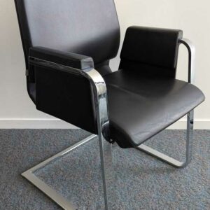 Suite de 4 fauteuils de marque INTERSTUHL modèle 550 A, structure en acier chromé, garniture en cuir noir, piètement en porte à faux.92 x 61 x 65 cm. Localisation : 7 ouest