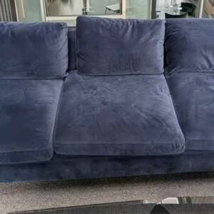 Canapé 3/4 places de marque MADE.COM recouvert de velours bleu, coussins amovibles, pieds en acier laqué noir. 60 x 220 x 95 cm. Localisation : 2 ème coursive