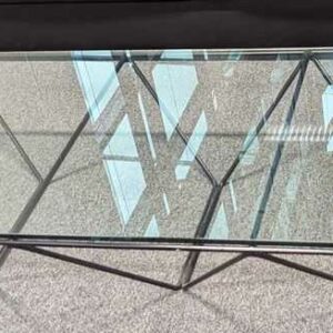 Table basse design Paolo Piva modèle Alanda, structure en acier tubulaire laqué noir, plateau en verre transparent. 26 x 120 x 60 cm. Localisation : 1 ouest