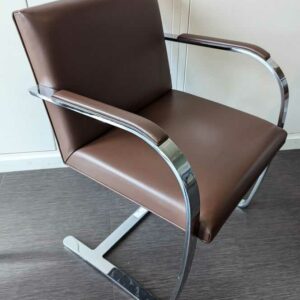 Fauteuil design Mies Von der Rohe modèle Brno édition KNOLL, structure en acier chromé, garniture en cuir marron. 80 x 58 x 55 cm. Localisation : 7 est