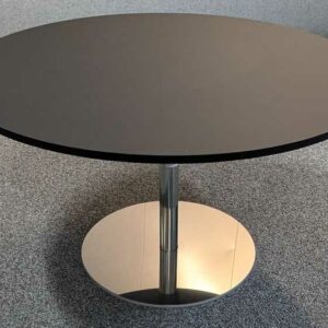 Table basse à plateau rond en bois laqué noir et piètement en acier chromé. 40 x 70 cm. Localisation : 7 ouest
