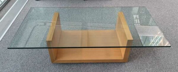 Table basse, plateau rectangulaire en verre reposant sur un socle en bois (petit éclat). 35 x 140 x 70 cm. Localisation : 5ème coursive