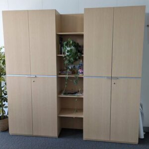 Armoire penderie en bois stratifié couleur chêne clair ouvrant par 4 portes. 218 x  226 x 43 cm. Localisation : 7 ouest