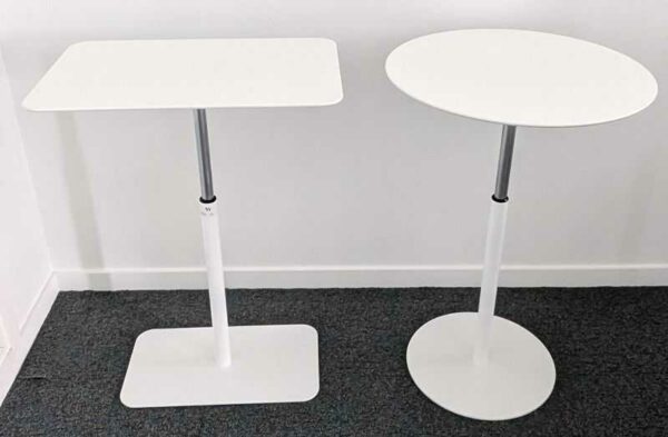 2 tables d'appoint réglables en hauteur en bois stratifié et acier laqué blanc, une ronde et une rectangulaire. Hauteur max: 76 cm . Hauteur mini : 53 cm. Localisation : 7 ouest