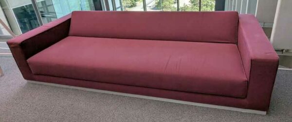 Canapé lit de marque TACCHINI recouvert de tissu couleur grenat. 55 x 255 x 100 cm. Localisation : 4ème coursive