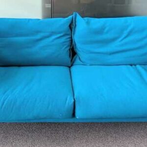 Canapé de marque MOROSO modèle Gentry recouvert de tissu chiné bleu, coussins amovibles, piètement en acier laqué noir. 83 x 207 x 80 cm. Localisation : 5 est