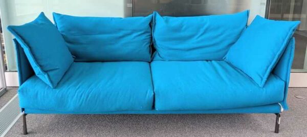Canapé de marque MOROSO modèle Gentry recouvert de tissu chiné bleu, coussins amovibles, piètement en acier laqué noir. 83 x 207 x 80 cm. Localisation : 5 est