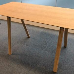 Table haute en bois couleur chêne clair, plateau rectangulaire reposant sur 4 pieds obliques. 104 x 200 x 90 cm. Localisation : 6 est – Image 2