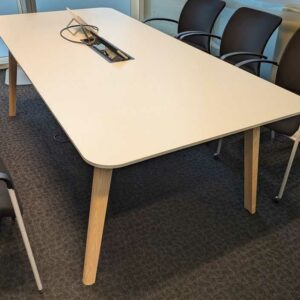 Table de réunion, plateau rectangulaire à bords arrondis en bois stratifié blanc avec trappe passe câble, piètement oblique en bois naturel. 73 x 220 x 100 cm. Localisation : 7 est
