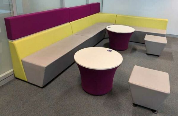 Espace d'attente de marque Connection en simili cuir vert et gris et feutrine violette, comprenant 4 banquettes, 2 tables et 2 poufs. 108 x 360 x 240 x 70 cm. Localisation : 6 est