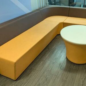 Espace d'attente de marque Connection comprenant 3 banquettes et 1 table ronde, en simili cuir orange et marron. 70 x 240 x 200 x 70 cm. Localisation : 5 ouest