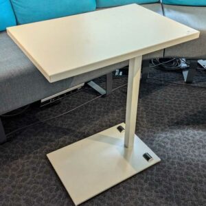 Table d'appoint à plateau rectangulaire en bois stratifié blanc, piètement en acier laqué blanc, avec 2 roulettes sous la base. 73 x 60 x 40 cm. Localisation : 5 ouest