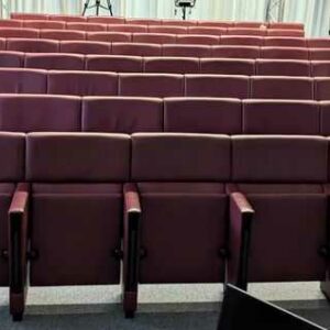 Rang de fauteuils de salle d'auditorium composé de 8 sièges en cuir bordeaux de marque POLTRONA FRAU avec tablette rétractable. 90 x 488 x 70 cm. Localisation : 7 est