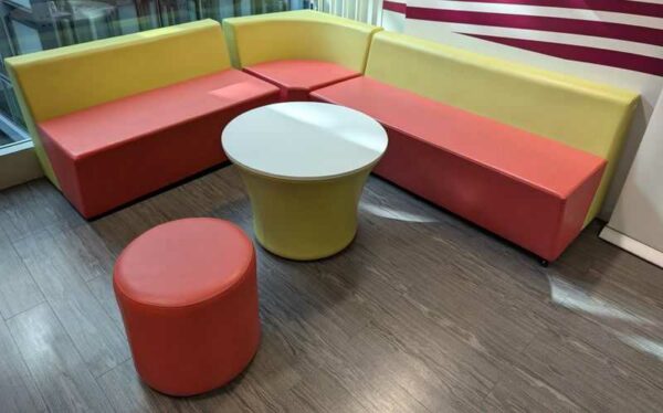 Espace d'attente de marque Connexion comprenant 1 banquette 3 places, 1 de 2 places, 1 d'angle (62 x 205 x 240 x 72 cm), 1 pouf et 1 table (57 x 75 cm). Localisation : 6 ouest