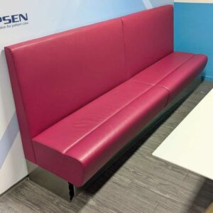 2 banquettes solidarisées recouvertes de simili cuir couleur framboise. 110 x 260 x 62 cm. Localisation : 4 est