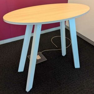 Table haute de marque STEELCASE plateau ovale en bois couleur hêtre, piètement oblique en acier laqué blanc. 100 x 120 x 60 cm. Localisation : 2 est