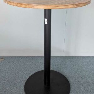 Mange debout, plateau rond en bois stratifié couleur noyer, pied colonne en acier laqué noir. 115 x 80 cm. 2 unités. Vendu à l'unité avec faculté de réunion. Localisation : 1 ouest, 1 est