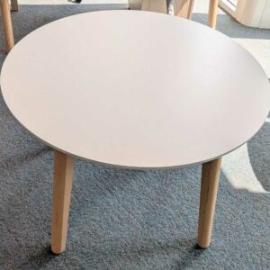 Table ronde en bois, plateau blanc reposant sur 4 pieds en bois naturel. 73 x 100 cm. Localisation : 5 est – Image 2