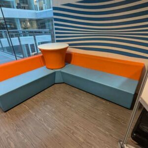Espace d'attente de marque CONNECTION en simili cuir bleu et orange comprenant 3 banquettes dont une d'angle et une table. 108 x 160 x 180 x 70 cm. Localisation : 3 est