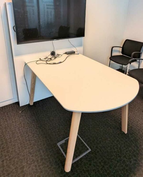 Table adossée en bois laqué blanc et pieds en bois naturel avec prise éléctrique intégréee. 155 x 155 x 120 cm. Localisation : 4 est