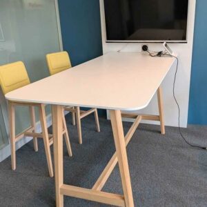 Table haute adossée en bois laqué blanc et pieds en bois naturel avec prise éléctrique intégréee. H 185 cm, diam table 105 x 200 x 90 cm. Localisation : 5 est