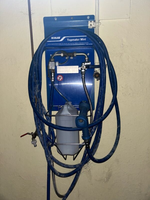 Centrale de nettoyage Ecolab Topmater mini bleu fixée situé au sous sol près des douches