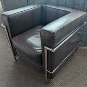 Fauteuil dans le goût du modèle LC2 de Le Corbusier en cuir marron, cadre en acier chromé. 67 x 76 x 70 cm. Localisation : Canada entrée