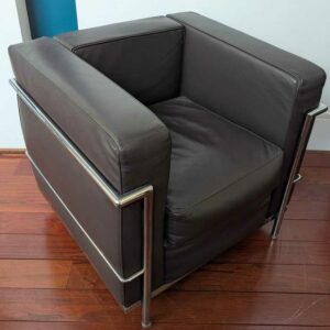 Fauteuil dans le goût du modèle LC2 de Le Corbusier en cuir marron, cadre en acier chromé. 67 x 76 x 70 cm. Localisation : Canada hall
