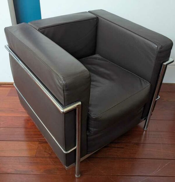 Fauteuil dans le goût du modèle LC2 de Le Corbusier en cuir marron, cadre en acier chromé. 67 x 76 x 70 cm. Localisation : Canada hall