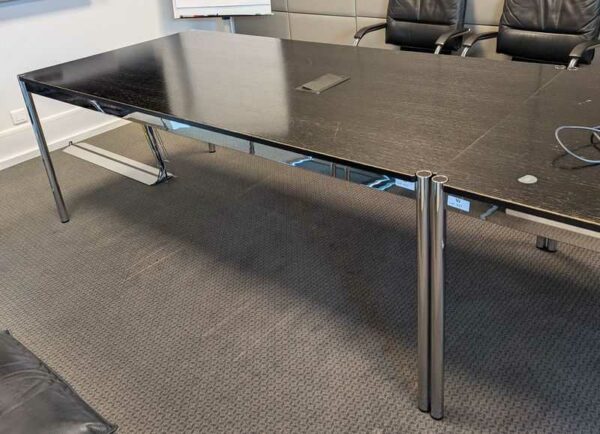 Table de réunion de marque USM HALLER, plateau en bois noir avec trappe passe câble électrifiée. 74 x 200 x 100 cm (usures). 2 unités. Vendu avec faculté de réunion. Localisation : Canada 1er (2c06)