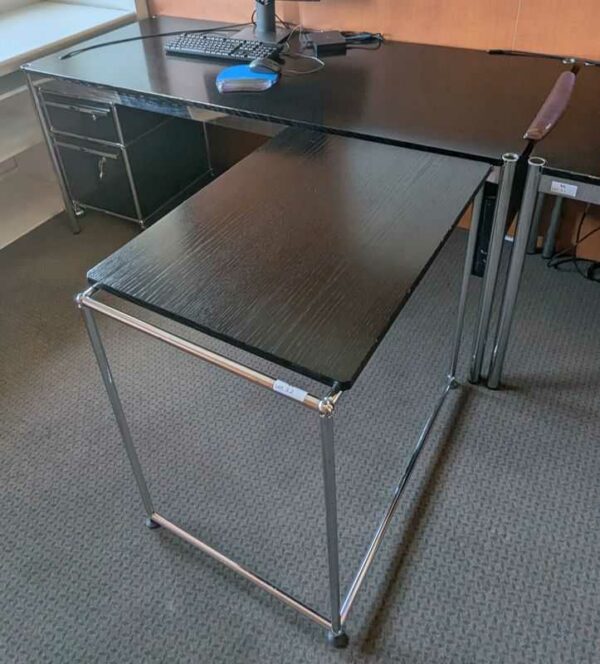 Bureau avec retour de marque USM HALLER, plateau en bois noir. 74 x 175 x 75 cm. Dimension retour : 74 x 79 x 54 cm (usures). Localisation : Canada 1er (2b02)