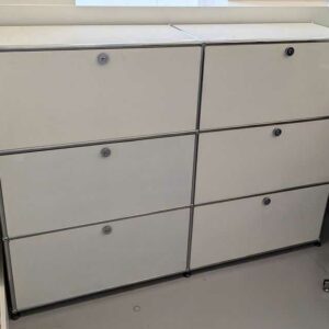 Meuble de rangement de marque USM HALLER à 6 compartiments ouvrant par portes à abattant de couleur blanche. 110 x 152 x 38 cm. Localisation : labo (1L7)