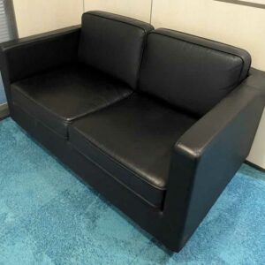 Canapé 2 places en cuir noir, coussins amovibles. 75 x 132 x 79 cm (usures, déchirure sur un coussin d'assise). Localisation : Theta 1er (près cafet)