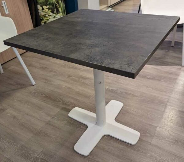 Table carrée à plateau en bois stratifié effet ardoise reposant sur un piètement colonne en acier laqué blanc. 77 x 70 x 70 cm. 2 unités. Vendu avec faculté de réunion. Localisation : Theta 1er cafet