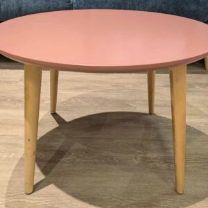 Table basse ronde plateau en bois stratifié rose reposant sur 4 pieds obliques en bois naturel. 40 x 60 cm. Localisation : Theta 1er cafet