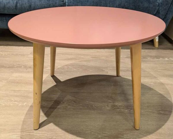 Table basse ronde plateau en bois stratifié rose reposant sur 4 pieds obliques en bois naturel. 40 x 60 cm. Localisation : Theta 1er cafet