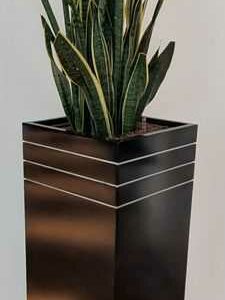 Pot rectangulaire en fibre de verre noir décoré de 3 bandes couleur argenté sur le bord supérieur. 120 x 34 x 34 cm. Localisation : Canada rdc haut (vers amphi)