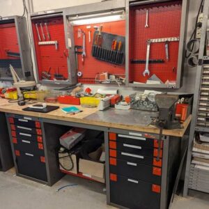 Etabli en bois avec 2 caissons en partie basse ouvrant par 2 fois 5 tiroirs avec étau. Localisation : Canada atelier