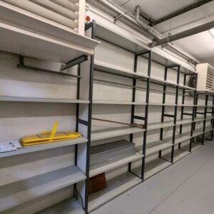 8,1 mètres linéaires de rayonnage en acier noir et gris comprenant 7 baies (largeur 117 cm; profondeur 40 cm), soit 8 échelles et 37 étagères. Localisation : Canada rdc bas