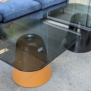2 Tables basses, plateau carré à bords arrondis en verre fumé, piètement conique en métal, l'un marron et l'autre en noir. 40 x 70 x 70 cm. Localisation : 2 est
