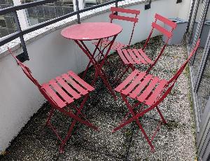 Mobilier de jardin pliable de marque FERMOB modèle Bistro comprenant une table ronde (72 x 60 cm) et 4 chaises en métal rouge (80 x 40 x 40 cm). Localisation : 10 rue du Ballon 93160 Noisy le Grand