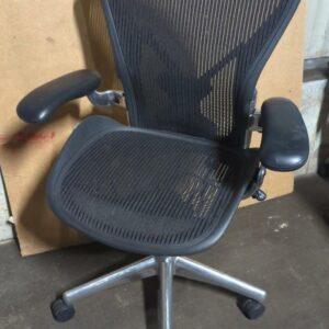 Fauteuil pivotant ajustable sur roulettes de marque Herman Miller modèle Aeron noir (2 picots arrière). 110 x 70 x 65 cm. Localisation : 8 rue de la Fossé aux Leux 91700 Ste Geneviève des Bois