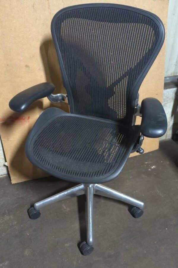Fauteuil pivotant ajustable sur roulettes de marque Herman Miller modèle Aeron noir (2 picots arrière). 110 x 70 x 65 cm. Localisation : 8 rue de la Fossé aux Leux 91700 Ste Geneviève des Bois