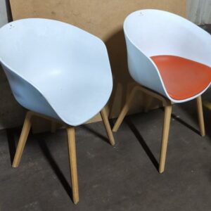 2 fauteuils design Hee Welling modèle About a Chair édition Hay, coque en plastique blanc dont 1 avec galette d'assise orange, pieds en bois. 80 x 55 x 50 cm. Localisation : 8 rue de la Fossé aux Leux 91700 Ste Geneviève des Bois