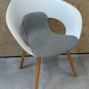 Fauteuil design Thomas Pedersen modèle Deli édition Skandiform, coque en plastique ajouré blanc, galette en tissu chiné gris clair, piétement en bois naturel. 80 x 62 x 55 cm. 2 unités vendues avec faculté de réunion. Localisation : 9 avenue Percier 75008 Paris