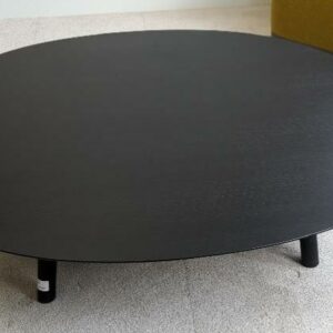 Table basse design Victor Carrasco modèle Maarten édition Viccarbe, plateau ovale en bois stratifié noir sur 4 pieds en métal. 30 x 124 x 120 cm. Localisation : 9 avenue Percier 75008 Paris