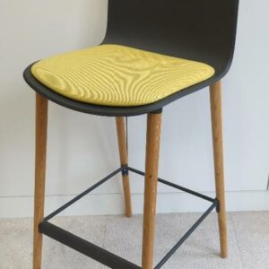 Chaise haute de marque Steelcase modèle Cavatina, coque en plastique gris anthracite, galette d'assise en tissu jaune, piètement en bois naturel avec repose-pied. 114 x 45 x 53 cm. 4 unités vendues avec faculté de réunion. Localisation : 9 avenue Percier 75008 Paris
