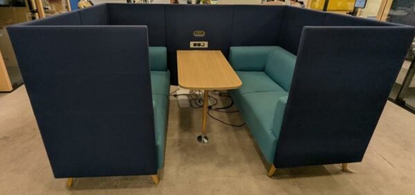 Espace de travail acoustique comprenant 2 banquettes 2 personnes en tissu vert, dossiers hauts en feutrine bleue, une table et prises électriques et Rj45. 131 x 242 x 163 cm. Localisation : 9 avenue Percier 75008 Paris